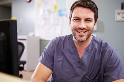 male nurse smiling at the nurse station