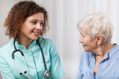 nurse having a conversation to senior woman